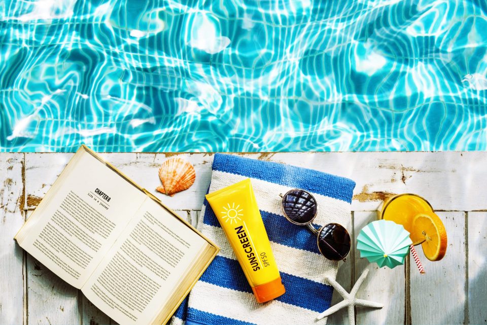Sunscreen sunglasses towel book recess relax concept